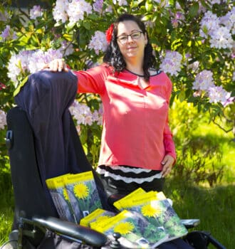 Tina ved siden af kørestol, hvori hendes bog Mælkebøttebarn i Blomst ligger. Fotograf Lars Walther Taknemlig for kærlighed