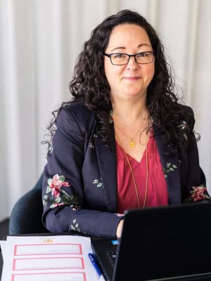 Tina i blomstret jakke ved pc med redskabspapirer på bordet ved siden af og god kommunikation